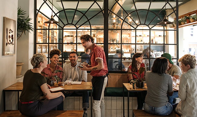 restaurant with server interacting with table of guests restaurant with server interacting with table of guests
